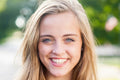 Woman with long blonde hair smiling outdoors